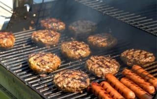 hamburgers and hotdogs on a charcoal grill