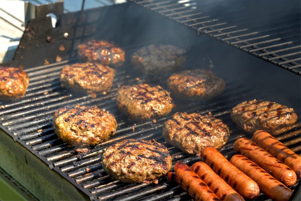 hamburgers and hotdogs on a charcoal grill