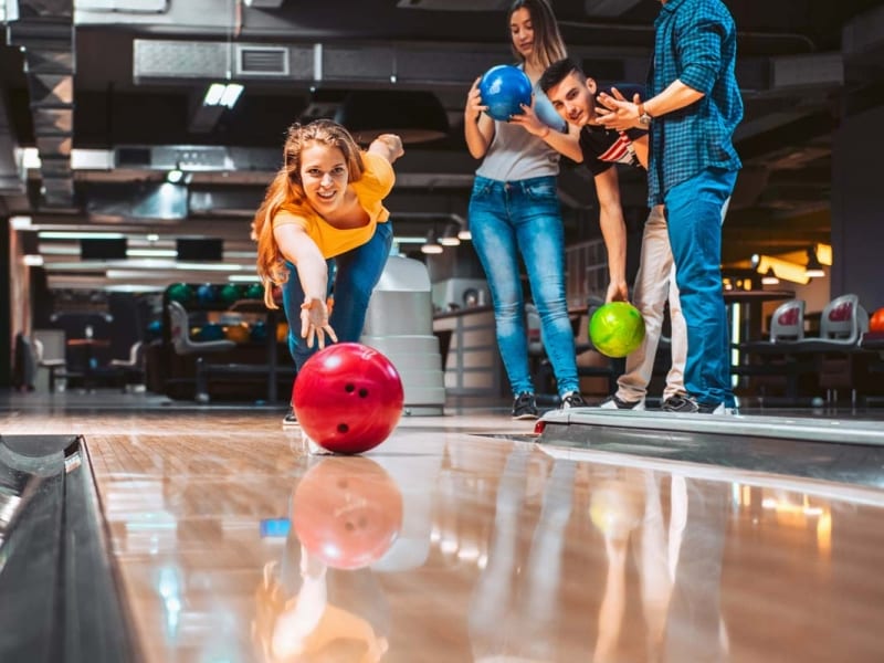 Woman bowling with friends.