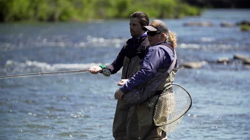 Man fly fishing with guide.
