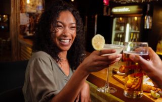 A woman enjoying a drink at a bar in Broken Bow, OK.