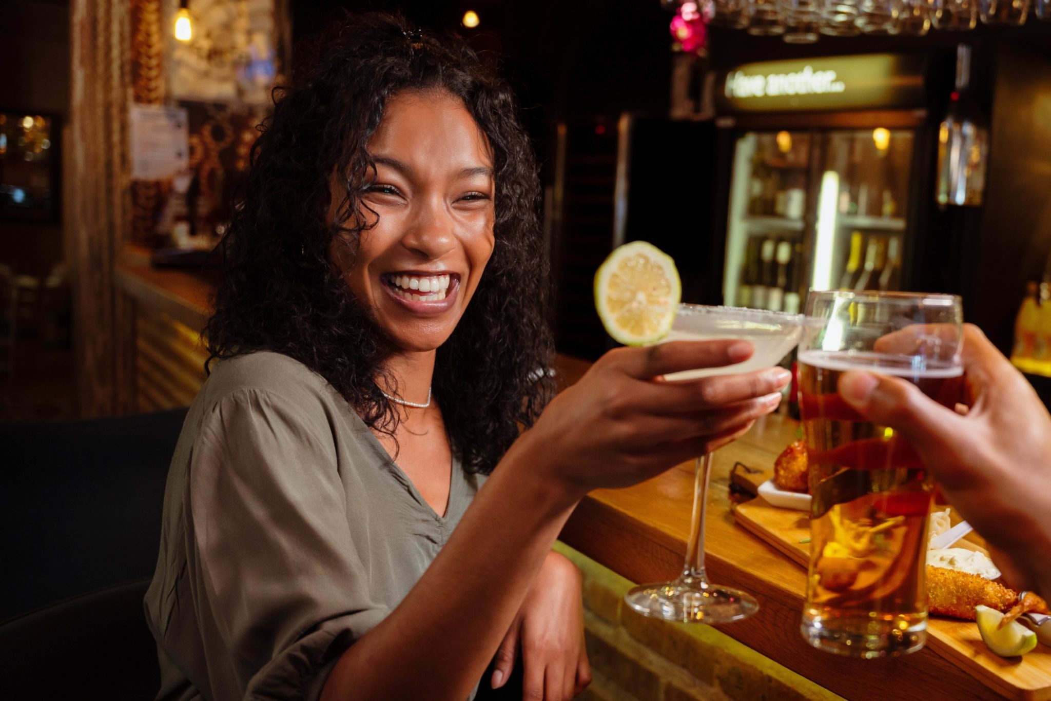 A woman enjoying a drink at a bar in Broken Bow, OK.
