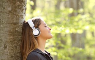 A woman outside listening to a Nature Podcast.