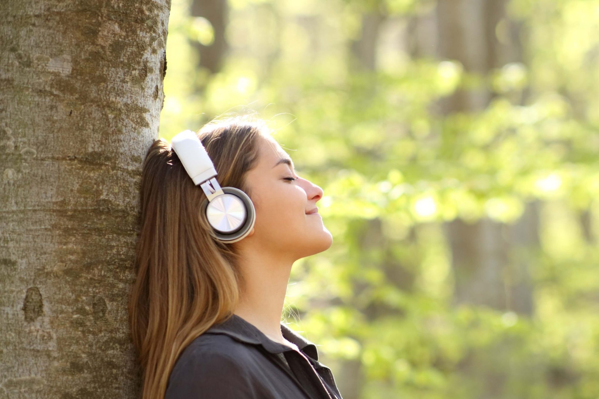A woman outside listening to a Nature Podcast.